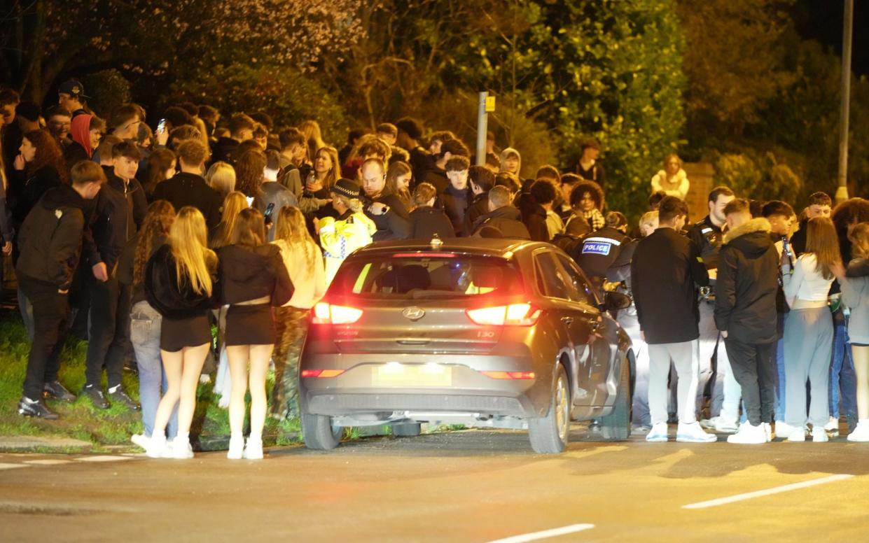 Police attempt to disperse hundreds of teenagers outside the house