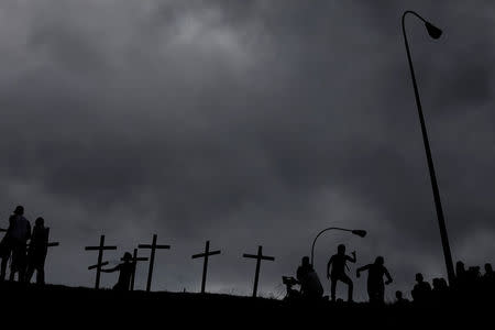 Opposition supporters place crosses with the names of victims of violence during the protests against Venezuela's President Nicolas Maduro's government, during a protest in Caracas, Venezuela May 15, 2017. REUTERS/Carlos Garcia Rawlins