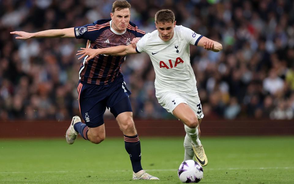 Micky van de Ven of Tottenham Hotspur holds off Chris Wood of Nottingham Forest