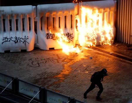 A demonstrator is seen next to a burning barricade during a protest in Hong Kong
