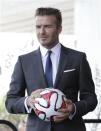 David Beckham poses with a soccer ball after discussing matters related to the ownership position he has with a proposed Major League Soccer (MLS) expansion team that could play in Miami, at a news conference in Miami, Florida February, 5, 2014. REUTERS/Andrew Innerarity