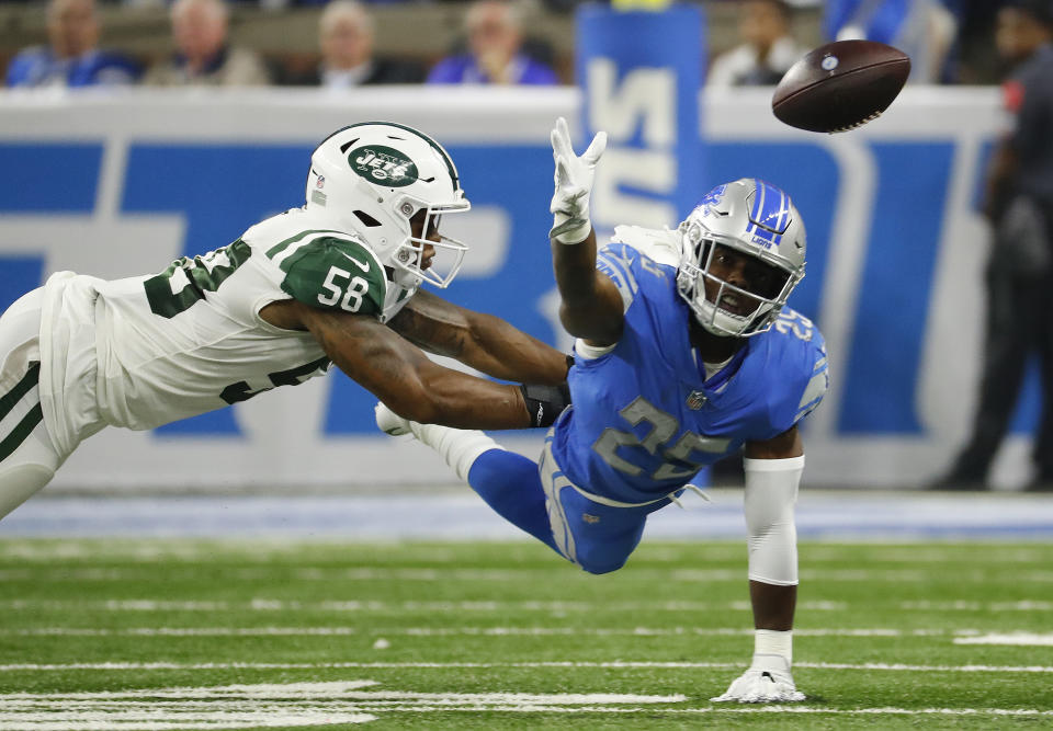 Detroit Lions running back Theo Riddick (25) reaches for the ball as New York Jets linebacker Kevin Pierre-Louis (56) defends in the first half of an NFL football game in Detroit, Monday, Sept. 10, 2018. (AP Photo/Rick Osentoski)