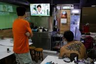 Men watch a TV broadcast of news conference of Hong Kong Chief Executive Carrie Lam inside a restaurant in Hong Kong