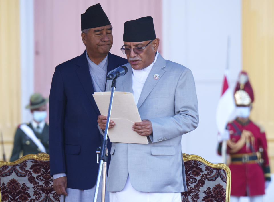 Nepal's former prime minister Sher Bahadur Deuba, left, reacts as newly elected prime minister Pushpa Kamal Dahal, right, takes oath during a ceremony at the President House in in Kathmandu, Nepal, Monday, Dec. 26, 2022. Dahal has appointed three deputies and four other ministers in the Cabinet that is expected to be expanded in the next few days to accommodate more members from the seven parties in the new coalition government. (AP Photo/Niranjan Shrestha)