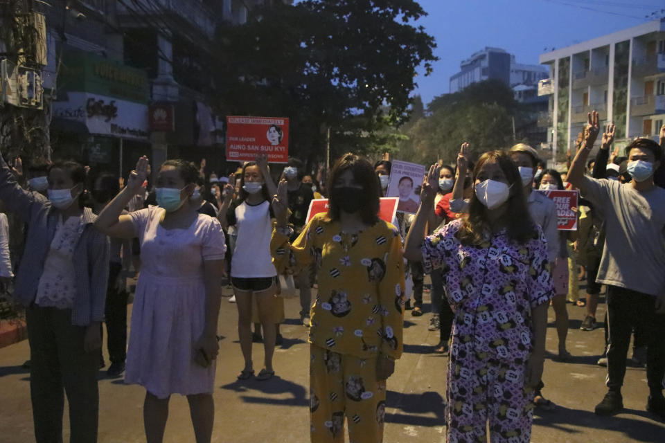 Anti-coup protesters flash three-fingered gesture, a symbol of resistance, during a rally outside their homes in downtown Yangon, Myanmar, Monday, March 22, 2021. Protests against the coup continued in cities and town across the country, including in Mandalay and Yangon. (AP Photo)