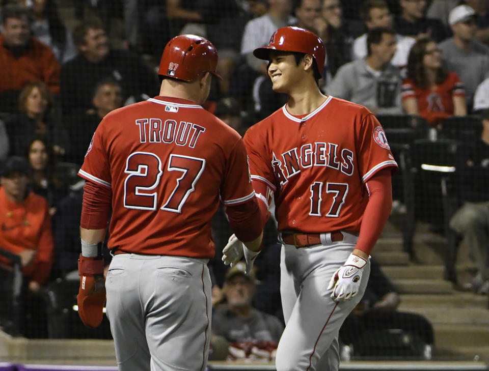 Los Angeles Angels' Shohei Ohtani (17) is greeted by Mike Trout (27) after hitting a three-run home run against the Chicago White Sox during the third inning of a baseball game, Friday, Sept. 7, 2018, in Chicago. (AP Photo/David Banks)
