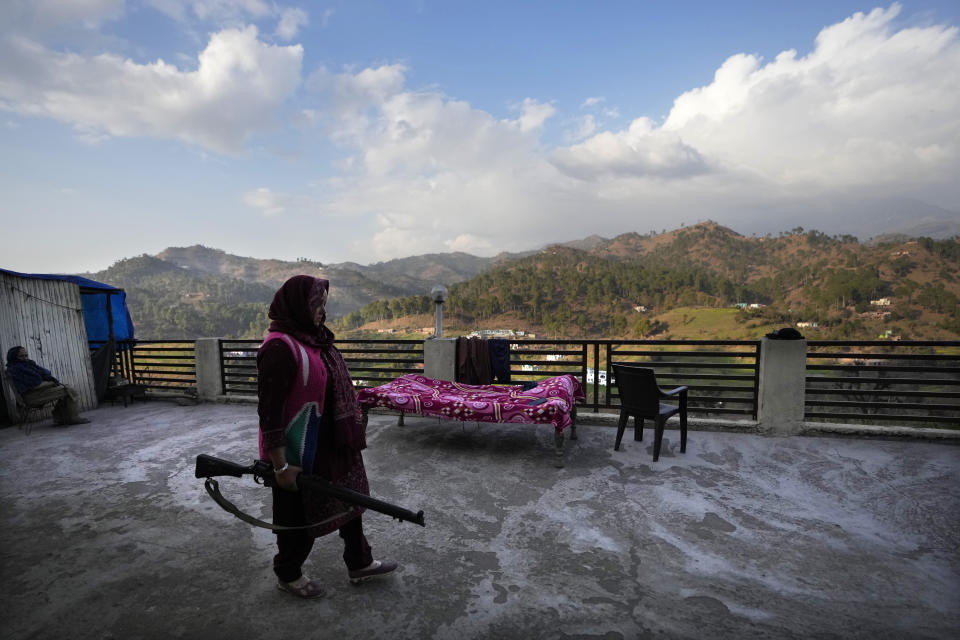 Village Defense Group member Usha Raina holding a gun stands on the rooftop of her house at Kalal Khas Village, in Rajouri, India, Feb. 7, 2023. Days after seven Hindus were killed in the village in disputed Kashmir, Indian authorities revived a government-sponsored militia and began rearming and training villagers. The militia, officially called the “Village Defense Group,” was initially formed in the 1990s as the first line of defense against anti-India insurgents in remote villages that government forces could not reach quickly. (AP Photo/Channi Anand)