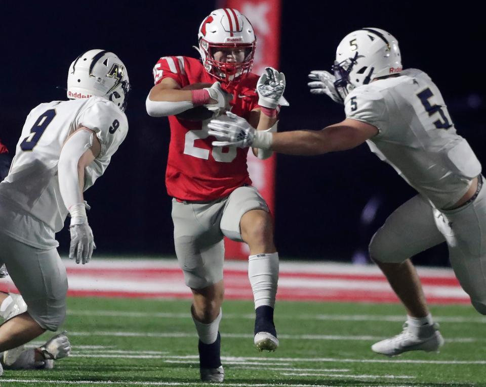 Kimberly's Marcus Doucette (25) runs against Appleton North's Cam Chudacoff and Brock Arndt (5) during their WIAA Division 1 football playoff game Friday in Kimberly.