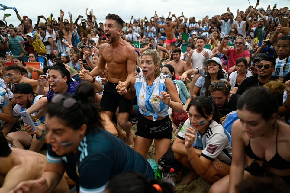 Fans of Argentina react while watching the live broadcast of the Qatar 2022 World Cup final football match between France and Argentina at the Copacabana beach in Rio de Janeiro, Brazil, on December 18, 2022. (Photo by MAURO PIMENTEL / AFP) (Photo by MAURO PIMENTEL/AFP via Getty Images)