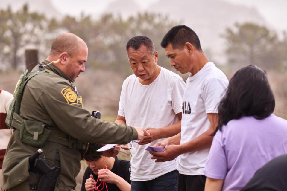 US Customs and Border Protection officers processed migrants after they crossed into the US from Mexico on Tuesday. James Keivom