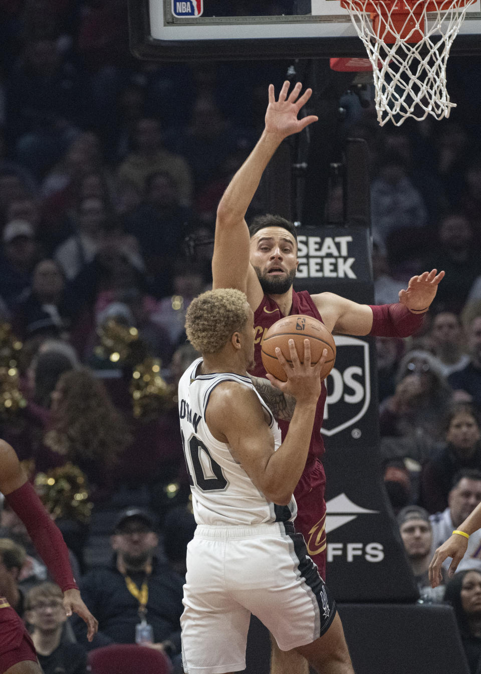 San Antonio Spurs' Jeremy Sochan (10) looks to pass as Cleveland Cavaliers' Max Strus defends during the first half of an NBA basketball game in Cleveland, Sunday, Jan. 7, 2024. (AP Photo/Phil Long)