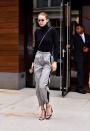 <p>Gigi just made those weird pants your 2nd grade crush used to wear look cool again. She paired her probably very loud windbreaker pants with a simple turtleneck, strappy heels, and angular shades. </p>