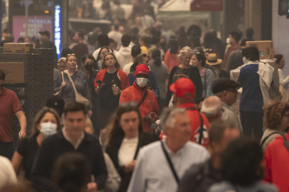 FILE - People wear face masks as they walk outside in the smoke-filled air in Herald Square, June. 7, 2023, in New York. More Americans believe they've personally felt the impact of climate change because of recent extreme weather according to new polling from The Associated Press-NORC Center for Public Affairs Research. (AP Photo/Yuki Iwamura, File)