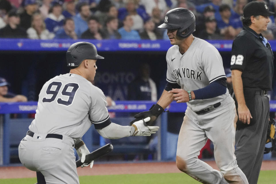 New York Yankees' Isiah Kiner-Falefa, right, is congratulated by Aaron Judge after scoring on a sacrifice fly by Gleyber Torres against the Toronto Blue Jays during the ninth inning of a baseball game Tuesday, May 16, 2023, in Toronto. (Chris Young/The Canadian Press via AP)