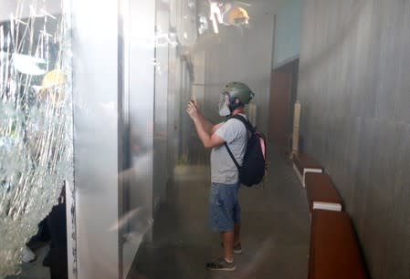 Man takes pictures inside the Legislative Council building as protesters try to break in during the anniversary of Hong Kong's handover to China in Hong Kong