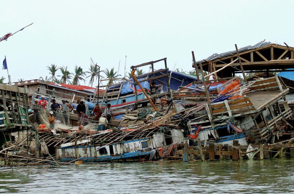 Survivors stand on houses destroyed by Cyclone Nargis in Haing Gyi island in 2008AFP/Getty