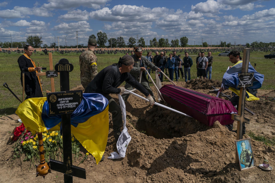 Relatives and friends attend the funeral of Ukrainian serviceman Vitaliy Nejenits in Kharkiv cemetery, eastern Ukraine, Friday, May 27, 2022. (AP Photo/Bernat Armangue)