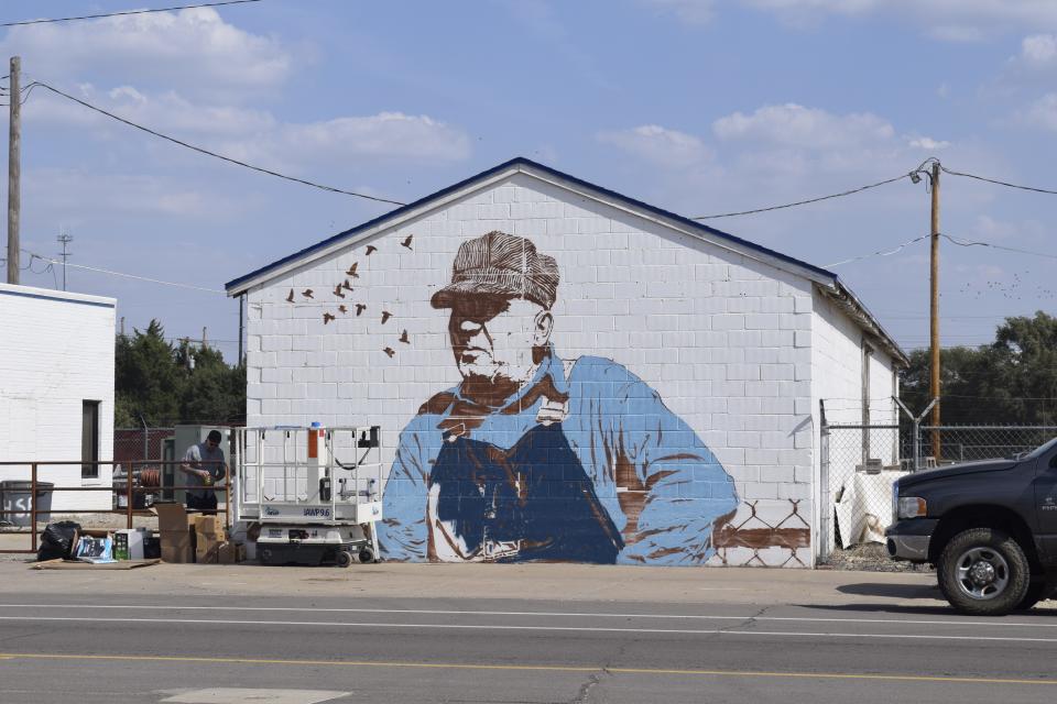 Chris Stain takes a quick break from painting his piece, titled "Keep 'em Rollin'" as of Monday. The mural, located on the east side of North Santa Fe Avenue, is part of the 2023 Boom! Salina Street Art and Mural Festival taking place in downtown Salina.