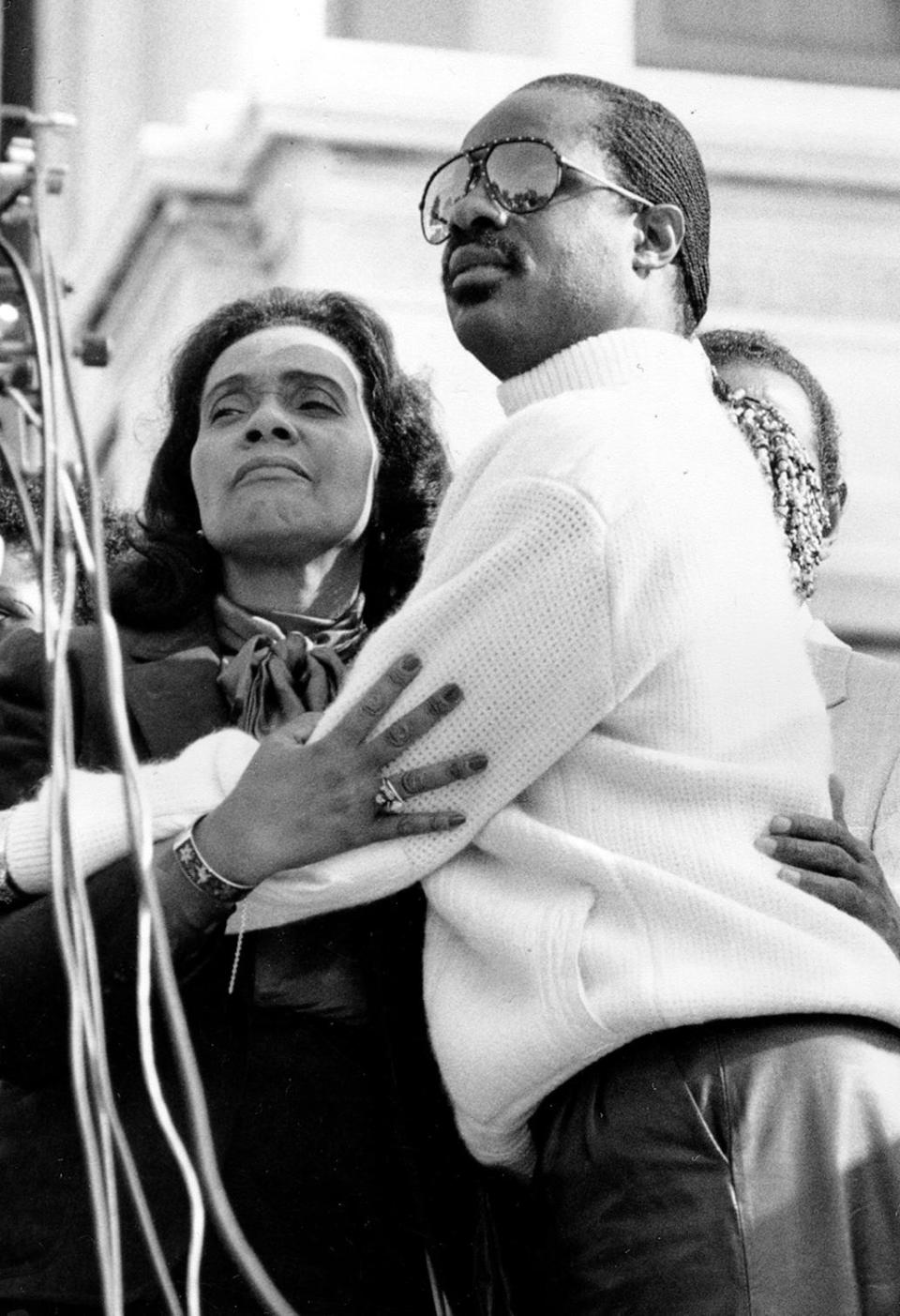 Coretta Scott King, widow of the Rev. Martin Luther King Jr., embraces singer Stevie Wonder during a celebration on the steps of the U.S. Capitol Building in Washington, D.C., Nov. 3, 1983.