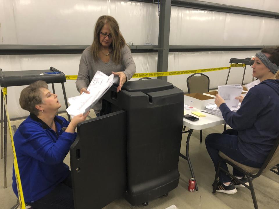 Lisa Leonard, left, hands ballots to Daviess County Deputy Clerk Sandy Kuegel during a recount of the Kentucky state House District 13 election on Saturday, Feb. 2, 2019, in Owensboro, Ky. Democrat Jim Glenn won the race by one vote, but the Republican controlled legislature ordered a recount at the request of GOP candidate DJ Johnson. (AP Photo/Adam Beam)