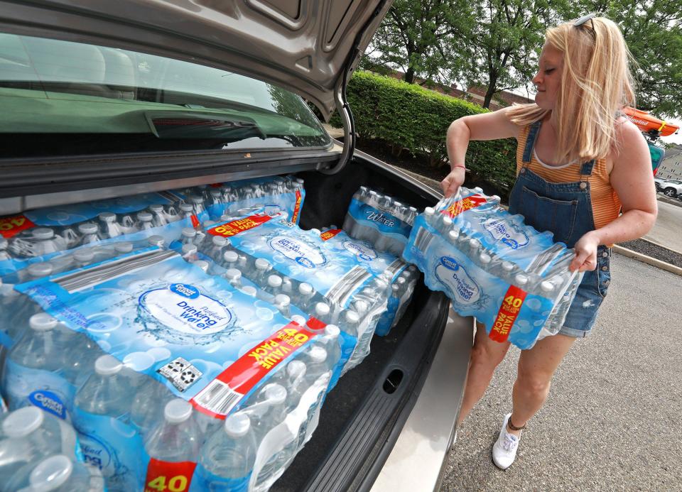 Camaren Sloan, from the Chamber of Greater Springfield, loads cases of donated drinking water into the trunk of her car Wednesday for transport to the tornado victims in the Dayton area. The Chamber posted on their Facebook page that they were taking donations and have gotten dozens of cases donated. (WHIO File)