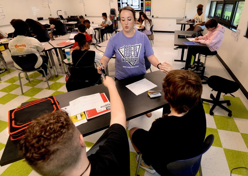 Eighth grade pre-algebra teacher Courtney Campo hands out some school supplies to students the first day of class at Washington Middle School on Monday, August, 21, 2023.