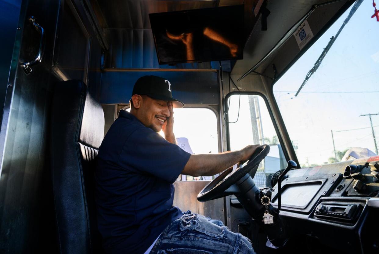 Taco truck owner Bryan Tecun sits in the driver's seat of his truck.