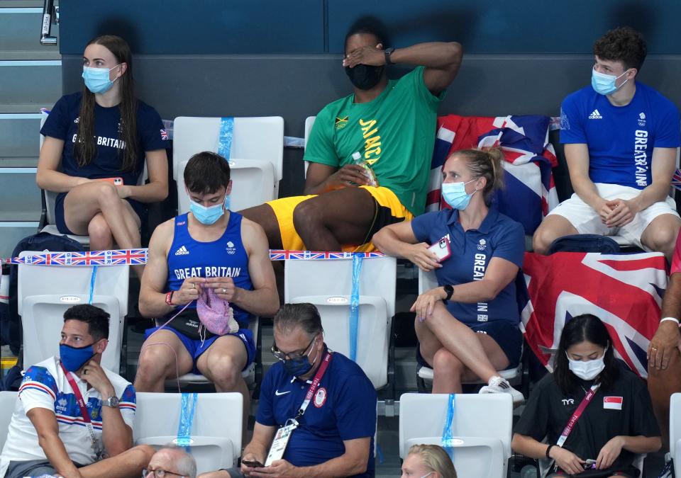 Tom Daley knits in the stands (Joe Giddens/PA) (PA Wire)