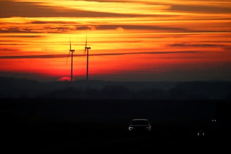 FILE PHOTO: Power-generating windmill turbines are pictured at sunset at a wind park in Fins near Cambrai