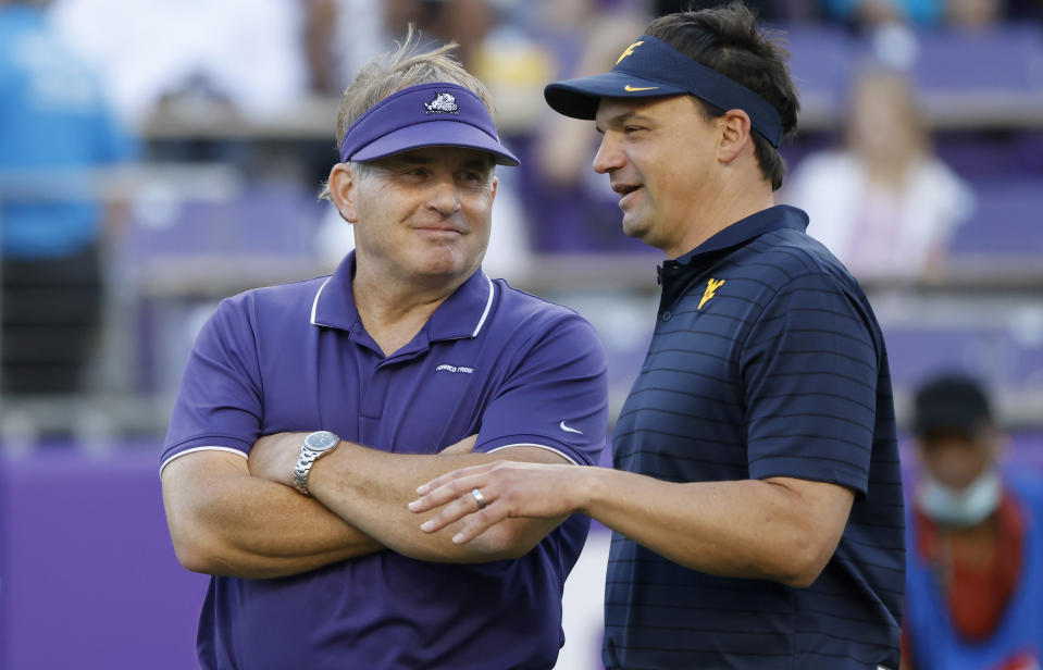 TCU head coach Gary Patterson, left, and West Virginia head coach Neal Brown talk on the playing field before an NCAA college football game Saturday, Oct. 23, 2021, in Fort Worth, Texas. (AP Photo/Ron Jenkins)