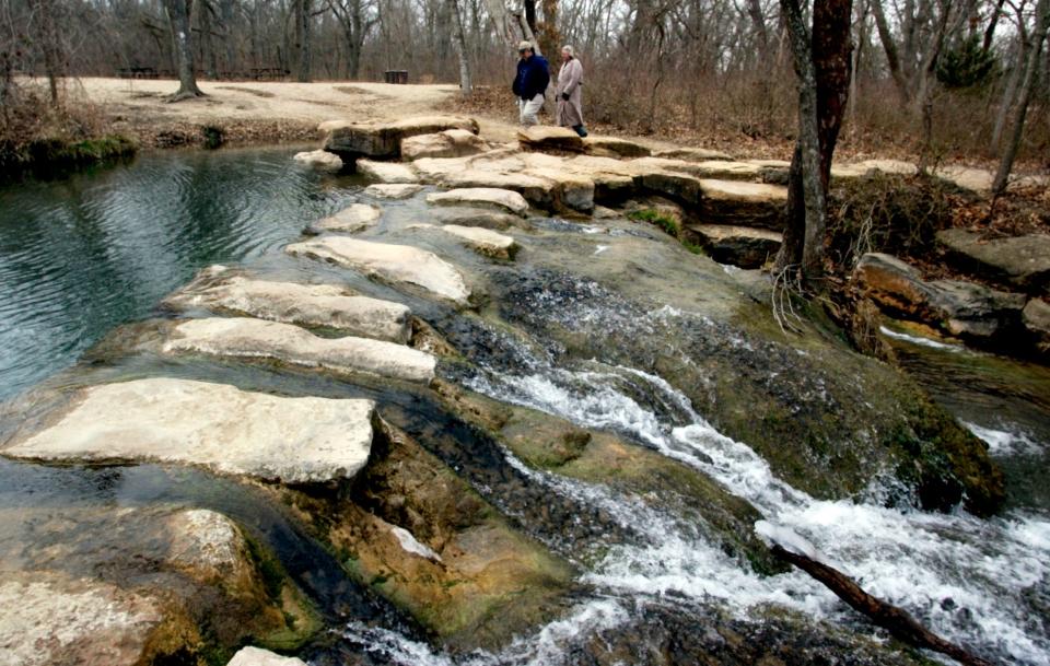 A couple walks along a rock bridge near the Travertine Nature Center in the Chickasaw National Recreation Area in Sulphur.