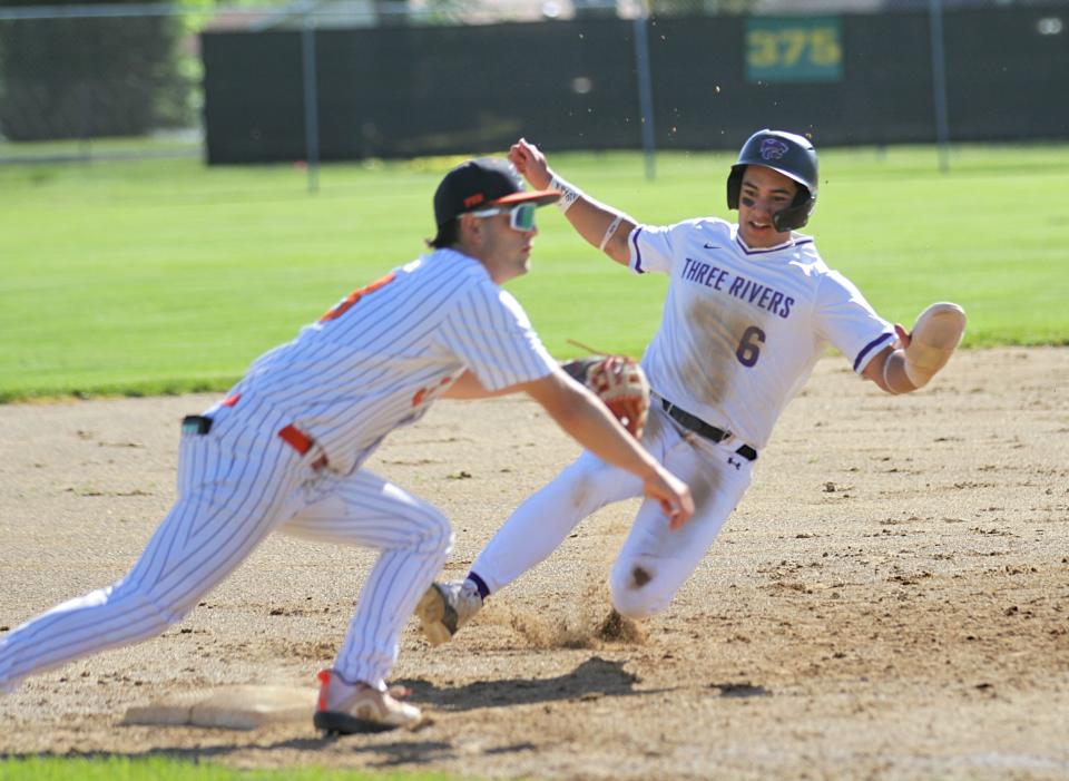 Three Rivers' Luis Warmack slides safely into third base before the tag from Sturgis' Taner Patrick on Wednesday.