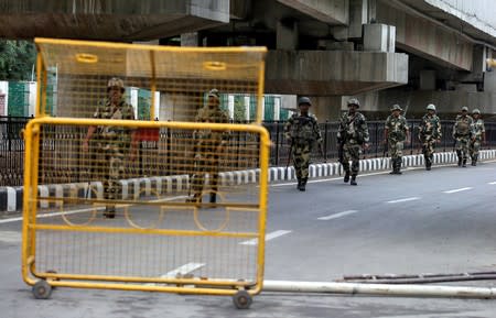 Indian security forces personnel patrol a deserted road during restrictions after the government scrapped special status for Kashmir, in Srinagar