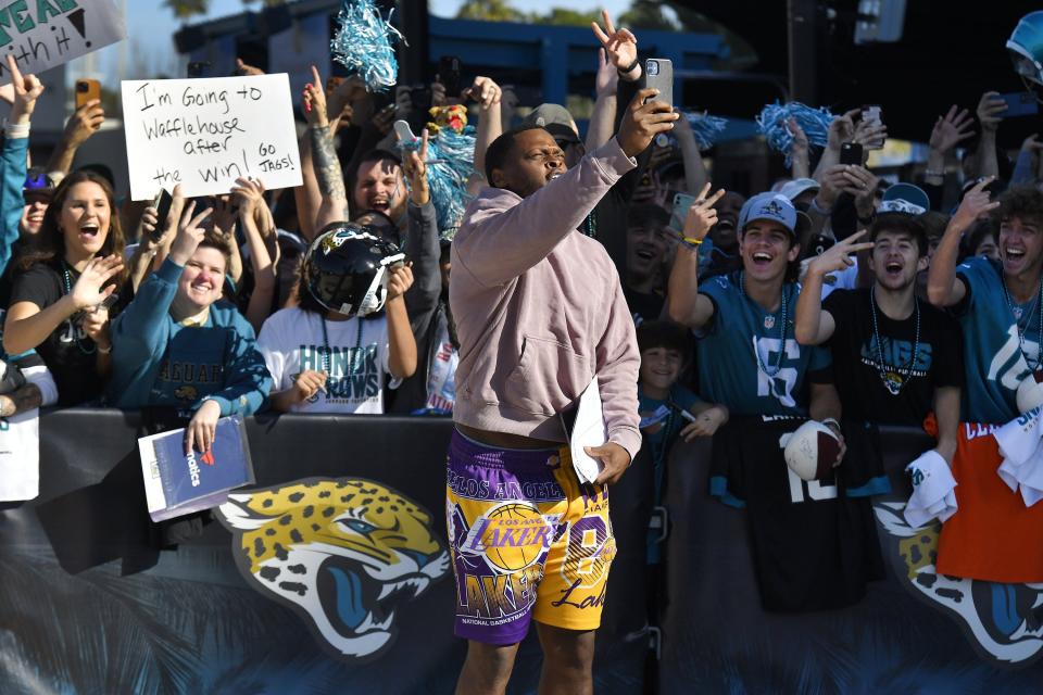 Jacksonville Jaguars linebacker Shaquille Quarterman takes a selfie with fans as he leaves the stadium Friday morning. Hundreds of fans waited outside the entrance of TIAA Bank Field to cheer on the team as they headed to their cars to drive to the airport for their flight to Kansas City to play their AFC divisional round game against the Chiefs on Saturday.
