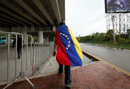 A Venezuelan man carries a Venezuelan flag during a small protest outside the site where the Organization of American States (OAS) 47th General Assembly is taking place in Cancun, Mexico June 21, 2017. REUTERS/Carlos Jasso