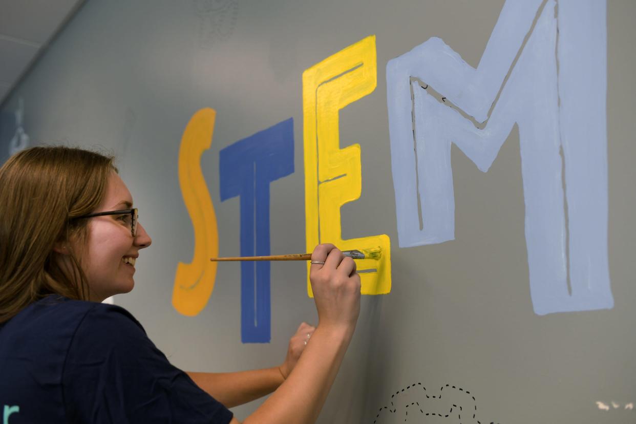 AbbVie employee Sarah Gregory paints the wall. About 150 AbbVie volunteers from the Worcester facility showed up at Forest Grove Middle School to work on a greenhouse and enhance the STEM lab. The group was volunteering to help develop an immersive, large-scale STEM lab on the school’s campus Wednesday.