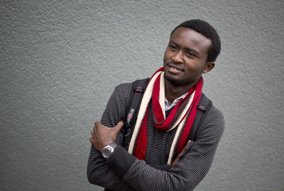 In this photo taken Monday, March 24, 2014, former student Blaise Ndizeye, 21, who has formed a fruit-selling cooperative and sells produce to the school, poses for a photograph at the Agahozo-Shalom Youth Village near Rwamagana, in Rwanda. Most of the kids in a school set amid the lush green, rolling hills of eastern Rwanda don't identify themselves as Hutu or Tutsi. That's a positive sign for Rwanda, which is now observing the 20th anniversary of its genocide, a three-month killing spree that, according to the official Rwandan count, left more than 1 million people dead, most of them Tutsis killed by Hutus. The teenagers attending the Agahozo-Shalom Youth Village, a school with dorms that creates tight-knit student families, say the ethnic slaughter that their parents or grandparents were a part of either as victims or perpetrators won't be repeated. The school director echoes the sentiment. (AP Photo/Ben Curtis)