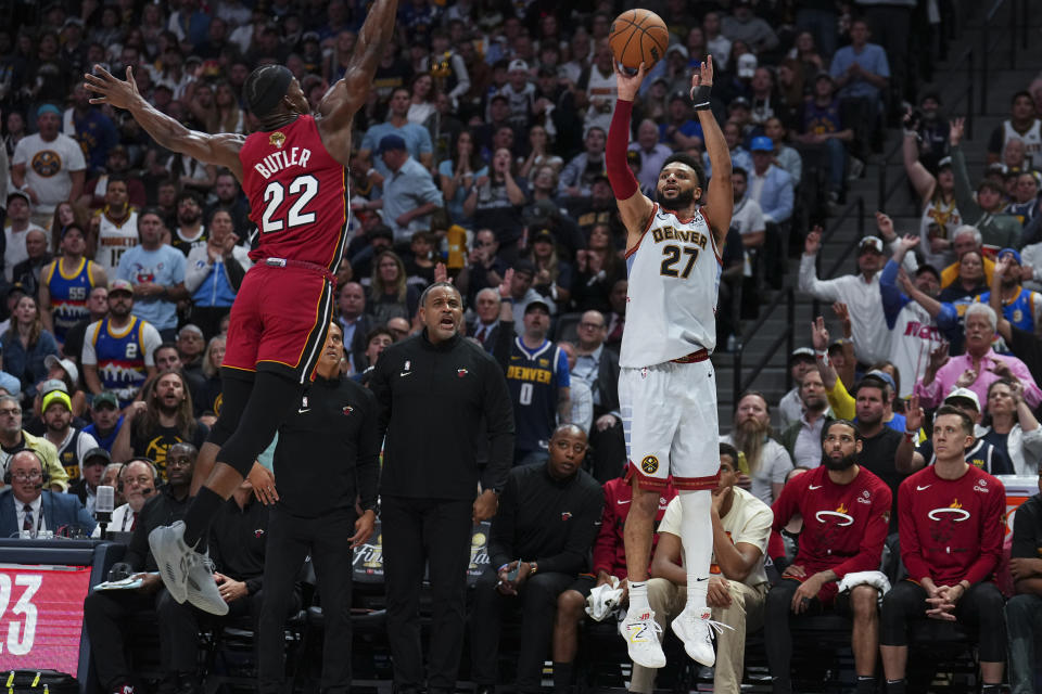 El base de los Nuggets de Denver Jamal Murray lanza un triple sobre el alero del Heat de Miami Jimmy Butler en el juego 5 de las Finales de la NBA el lunes 12 de junio del 2023. (AP Foto/Jack Dempsey)