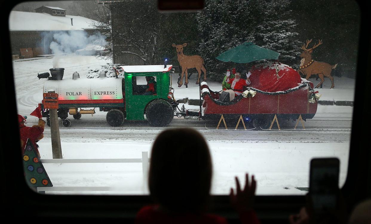 A child waves to Santa at the North Pole on from the Polar Express on Tuesday, Dec. 12, 2017, at Coventry High School in Akron, Ohio. FirstEnergy and the LeBron James Family Foundation rented the train ride out for Akron third graders in the I Promise program. (Leah Klafczynski/Beacon Journal/Ohio.com)