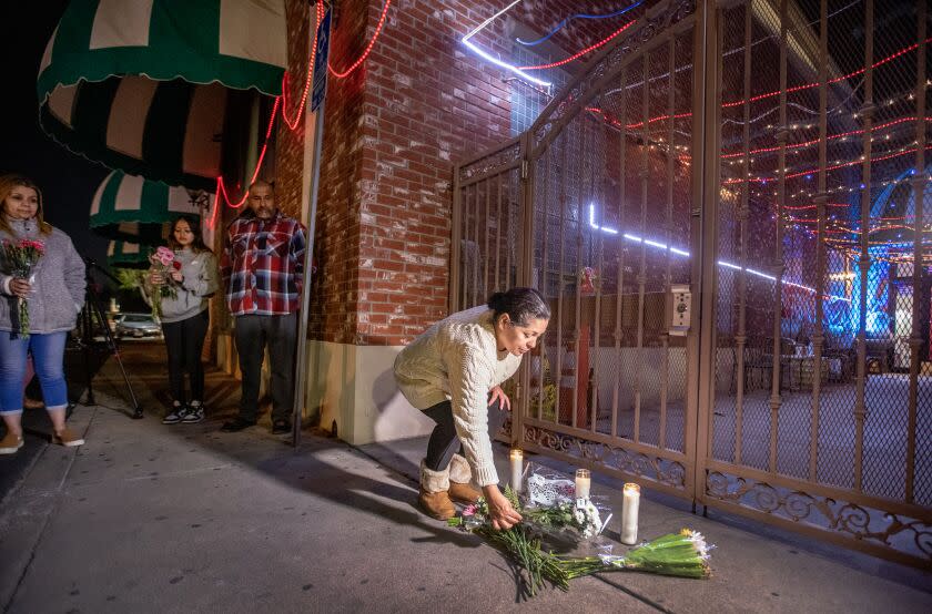 Monterey Park, CA - January 22: After police tape was taken down, people line up to place flowers at the entrance to the Star Dance Studio Ballroom where Huu Can Tran, a 72 year old Asian male, is accused of shooting and killing 10 people and injuring 10 during the Monterey Park mass shooting that took place Saturday night. Photo taken Sunday, Jan. 22, 2023. (Allen J. Schaben / Los Angeles Times)