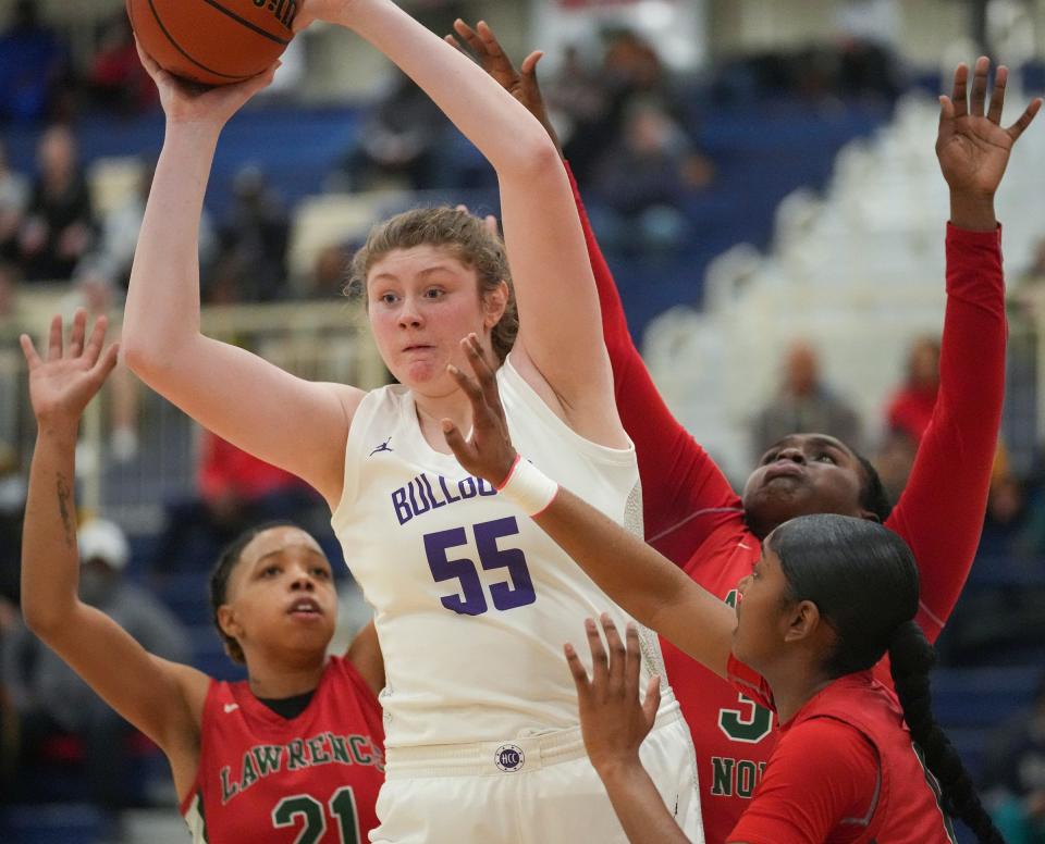 Brownsburg Bulldog Avery Gordon (55) gets rid of the ball as she is surrounded by Lawrence North defenders Saturday, Feb. 11, 2023, during IHSAA 4A regionals at Decatur Central in Indianapolis. Lawrence North defeated Brownsburg, 65-58, advancing to semi-state. 