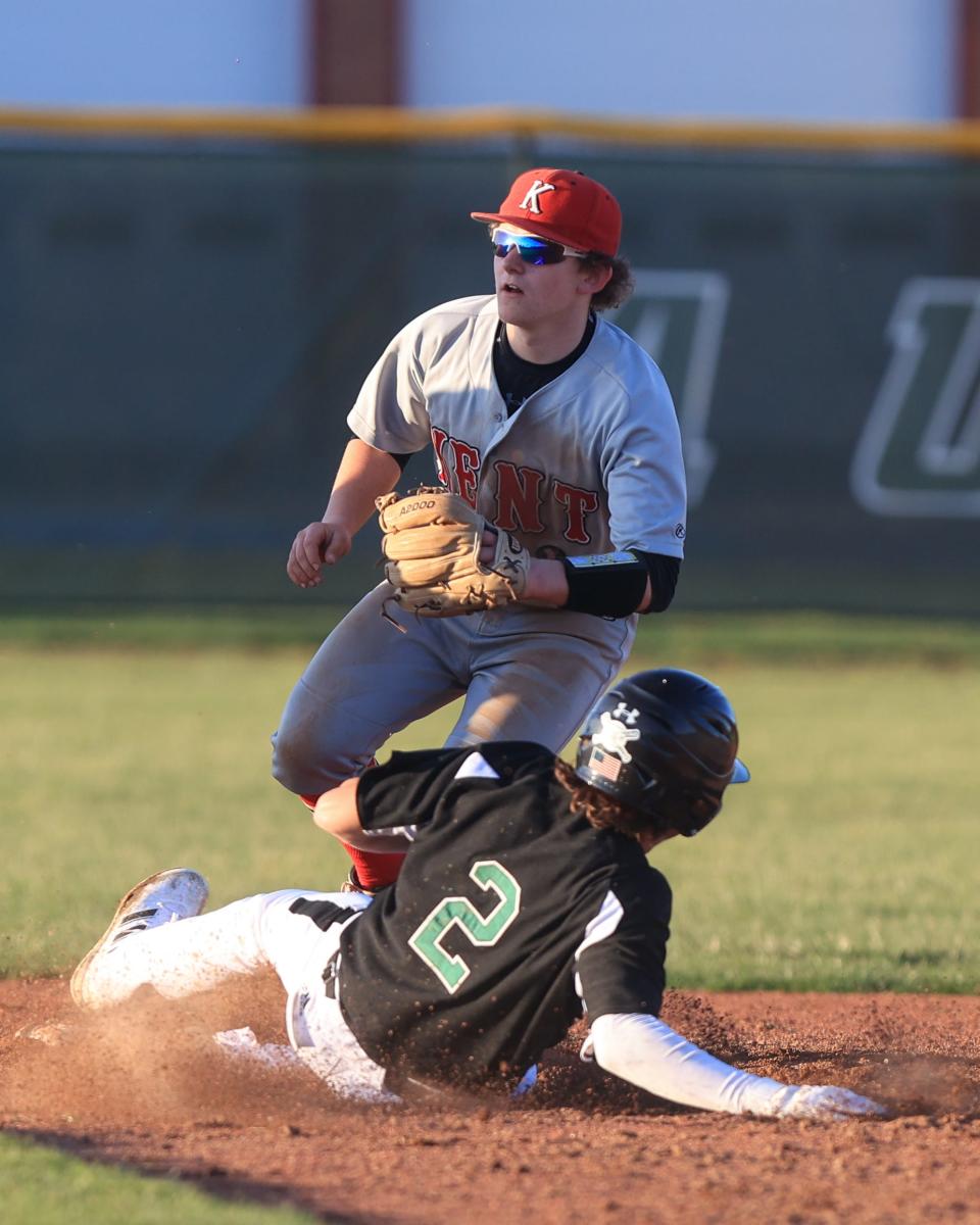 Aurora senior Jack Cardaman slides into second base as Kent Roosevelt sophomore Ryan Schromm looks for the throw during Tuesday night’s game at Aurora High School.