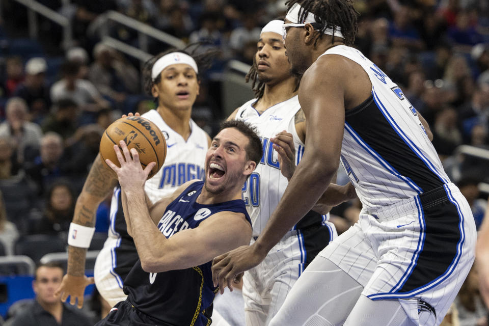 Indiana Pacers guard T.J. McConnell (9) drives past three Orlando Magic defenders during the first half of an NBA basketball game Wednesday, Jan. 25, 2023, in Orlando, Fla. (AP Photo/Kevin Kolczynski)