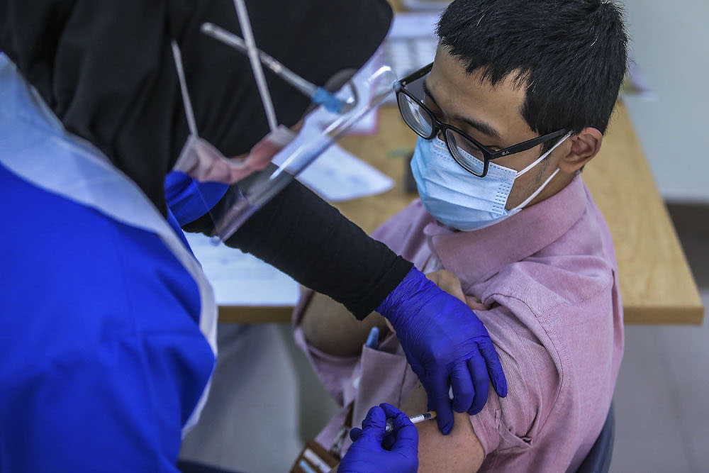 A healthcare worker administers a dose of the Pfizer-BioNTech Covid-19 vaccine to a frontliner at the UiTM Private Specialist Centre in Sungai Buloh March 2, 2021. ― Picture by Hari Anggara