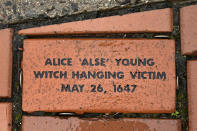 In this Tuesday, Jan. 24, 2023 photo, a brick memorializing Alice 'Alse' Young is placed in a town Heritage Bricks installation in Windsor, Conn. Young was the first person on record to be executed in the 13 colonies for witchcraft. Now, more than 375 years later, amateur historians, researchers and descendants of the accused witches and their accusers, from across the U.S., are urging Connecticut officials to officially acknowledge this dark period of the state's colonial history and posthumously exonerate those wrongfully accused and punished. (AP Photo/Jessica Hill)