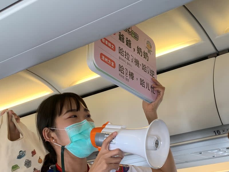 Guide holds signs on a Tigerair Taiwan flight that circles over South Korea's Jeju Island before returning to Taoyuan