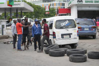 People argue with each other as cars queue to buy fuel at the Nigerian National Petroleum Company Limited petrol station in Lagos, Nigeria, Tuesday , May 30, 2023. Nigerian President Bola Tinubu has scrapped a decadeslong government-funded subsidy that has helped reduce the price of gasoline, leading to long lines at fuel stations Tuesday as drivers scrambled to stock up before costs rise. (AP Photo/Sunday Alamba)