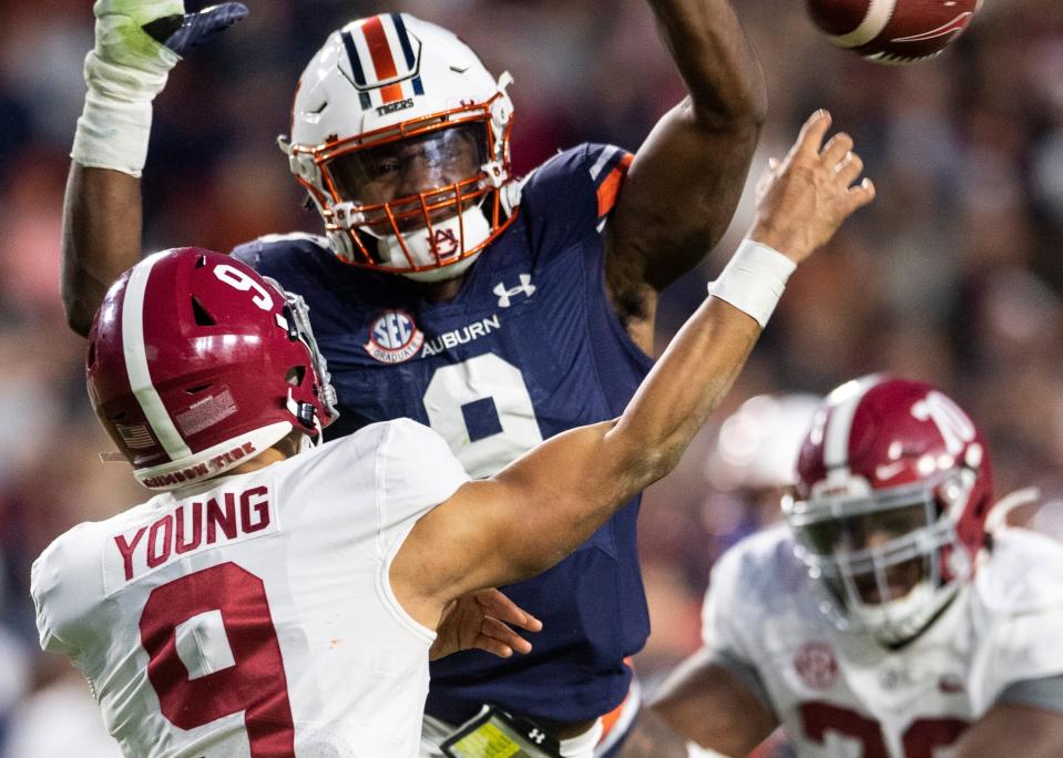 Auburn linebacker Zakoby McClain pressures Alabama quarterback Bryce Young as he throws a pass during the 2021 Iron Bowl game at Jordan-Hare Stadium in Auburn, Ala. The Crimson Tide won 24-22 in a four-overtime thriller.