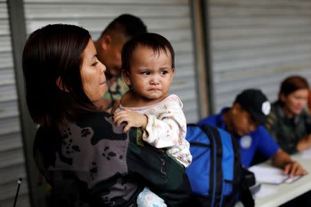 A two-year old Joana is carried by a Philippine soldier after being rescued by humanitarian volunteers with her family after spending more than a month caught up in the middle of the fighting in the centre of Marawi City, Philippines June 25, 2017. REUTERS/Jorge Silva