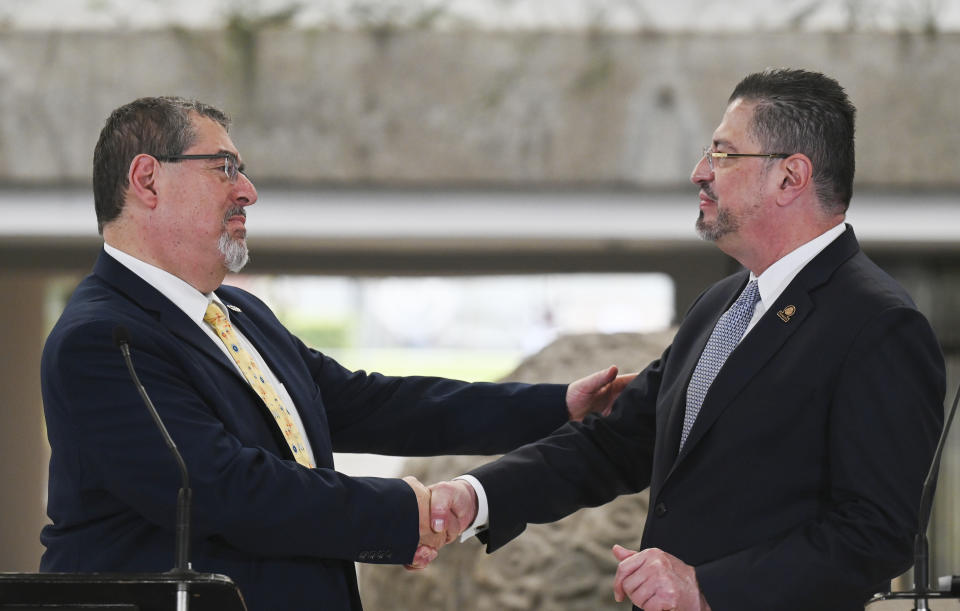 Guatemalan President-elect Bernardo Arévalo, left, and Costa Rica's President Rodrigo Chaves, shake hands during a welcoming ceremony in San Jose, Costa Rica, Wednesday, Dec. 13, 2023. Chaves received Arévalo Wednesday as the visiting politician tries to face down prosecutors’ attempts at home to derail his inauguration in barely a month’s time. (AP Photo/Carlos Gonzalez)